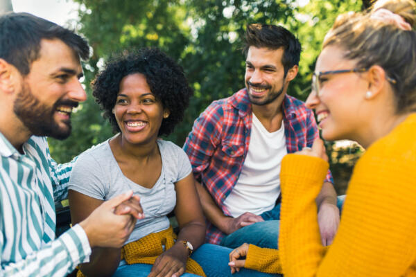 Woman with ear hearing problem having fun with her friends in the park